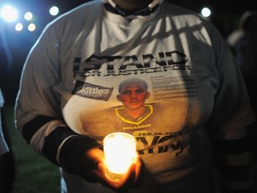 A supporter wearing a t-shirt with a photograph of teenager Trayvon Martin on it joins others in candlelight vigil at the exact moment when Martin was shot one year ago by neighbourhood watch volunteer George Zimmerman in Sanford, Florida February 26, 2013. (REUTERS/Brian Blanco)