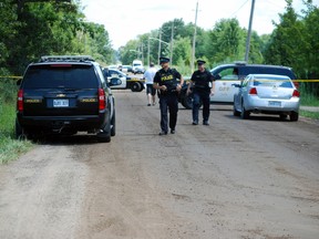 OPP officers maintain an Elijah Rd. roadblock as they investigate a shootout on the Oneida of the Thames First Nations settlement Aug. 3. A teen shot in that gun battle with police faces multiple charges. (BEN FORREST, QMI Agency)