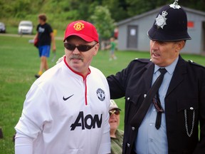 Steve Jennings, left, a fixture in the St. Thomas soccer community, stands with friend Peter Reed, who dressed as a British police officer for a charity soccer tournament in Athletic Park on Saturday. The tournament was a fundraiser for Jennings' health expenses as he struggles with Huntington disease. Ben Forrest/QMI Agency/Times-Journal