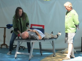 Port Dover illusionist Lucas Wilson cut Brian Reichheld of the Two Fairly Fat Guys in half on Sunday,August 4, 2013 at the Simcoe Rotary Friendship Festival. Looking on is Dan Barker, the other member of the Two Fairly Fat Guys. (KIM NOVAK Simcoe Reformer)