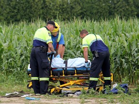 Emergency personnel attend to a teen boy who was injured after being hit by a vehicle near a cornfield on Jenner Line in the Harwich area on Monday near Chatham, Ont., around 12:30 p.m. ELLWOOD SHREVE/ THE CHATHAM DAILY NEWS/ QMI AGENCY