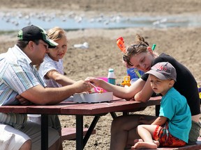 The Bulduc family, from left, Mario, Jasmine, Vincent and Diane shared a snack on Port Burwell’s East Beach around noon Saturday, as Tub Daze 2013 kicked off under beautiful, sunny skies. Jeff Tribe/Tillsonburg News
