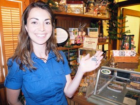 Heather Ridge, museum assistant at the Delhi Tobacco Museum and Heritage Centre shows off on the the key chains the museum is giving out to the first 50 visitors to ring the shopkeeper's counter bell and sing a portion of Stompin' Tom Conners' “Tillsonburg” as part of Norfolk County's Footsteps of Rock Legends tour. (SARAH DOKTOR Delhi News-Record)