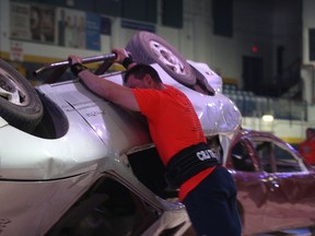 Elijah Hall flips a silver Pontaic Sunfire over for the second time Saturday during the Fifth Oilsands Classic at the Casman Centre. The Strongman competition saw 11 participants fight over $7,000 in cash and prizes. ROBERT MURRAY/TODAY STAFF