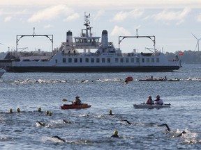 Men competing in the long-course triathlon begin the swim portion of the race in Confederation Basin during Sunday’s K-Town Triathlon. (Danielle VandenBrink The Whig-Standard)