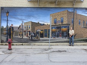 Allen Hilgendorf with the final mural he painted in Mildmay. (SUBMITTED)