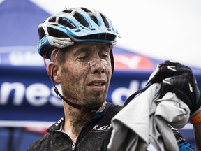 A muddy faced Leighton Poidevin of Canmore inspects his medal upon finishing the final stage of the Transrockies Challenge Mountain Bike Race on Friday. Justin Parsons/ Crag & Canyon/ QMI Agency