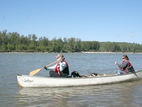EPBR Environmental Technician Robyn Anderson (front) and Science and Reclamation Coordinator Kerri Widenmaier (back) canoe out to a remote site in Eagle Point - Blue Rapids park to plant trees July 30.
