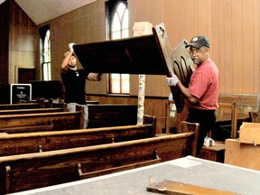 Andrae Cutler-Robbins, left, and father Tim Robbins, move a pew out of the First Baptist Church in North Buxton to be repurposed into a number of items.  After a lengthy dialogue with the community and descendants directly related to the church, which was built in 1883, the decision was made to tear down the building and adjacent parsonage. 
(DIANA MARTIN, Chatham Daily News)
