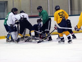 Players battle for the puck in front of the net at the opening of the Woodstock Navy Vets tryout camp Tuesday Aug. 6, 2013 on the green pad at Southwood Arena. The camp has three more dates before training camp and the regular season begin in September.