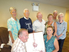Neighbours who survived the the Woodstock tornado of 1979 gathered to share memories of the tragedy on its 34th anniversary on August 7, 2013. Back row from left:  Susan Hampson, Gus Mowat, Bill Hampson, Betty Hampson, Barry Merkley, Betty Merkely. In front Robert and Teena Hird show off a photo of Mowat's bathtub wrapped around a tree following the tornado. HEATHER RIVERS/WOODSTOCK SENTINEL-REVIEW
