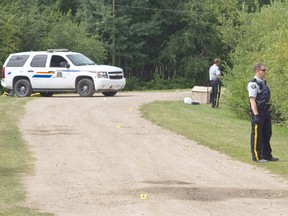 Members of the RCMP block a driveway outside of Ma-Me-O Beach, Alta., while the Alberta Serious Incident Response Team investigates on Sunday, August 4, 2013. According to RCMP, a man was fatally shot after being pulled over during an impaired driving investigation at 9:30 p.m. Aug. 3.