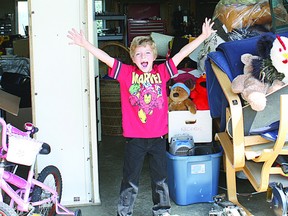Austin Neufeld gets ready for his garage sale, where he hopes to raise $1,000 to donate to cancer research. Photo Supplied