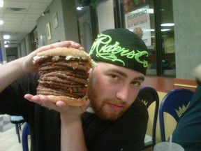 Robert Drolet poses with a 15-patty Whopper at Burger King. The local burger lover says he doesn't think lab-grown beef can compete with the real thing.