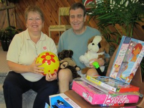 Guests at the Triple C Bible Camp near Fisher’s Glen recently rounded up a whack of new toys during a “Christmas in July” celebration. The Salvation Army in Simcoe will distribute the loot this December as part of its Christmas Exchange program for needy families. At right is Jim Stuart, chair of the Triple C board of directors. At left is Cherrie Ryerse, community and family services co-ordinator with the Salvation Army Community Church in Simcoe.    (MONTE SONNENBERG Simcoe Reformer)