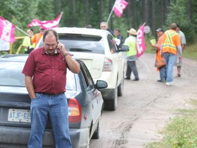 Mayor Randy McLaren calls the Ontario Provincial Police Wednesday outside the landfill site in Bonfield after he and another member of council were denied access by striking municipal workers. The workers eventually allowed the two to enter without police involvement.