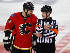 Calgary Flames' enforcer Brian McGrattan (L) laughs with referee Stephen Walkom in a break during the second period of their NHL hockey game against the Anaheim Ducks' in Calgary, Alberta, April 19, 2013. REUTERS/Todd Korol  (CANADA - Tags: SPORT ICE HOCKEY)