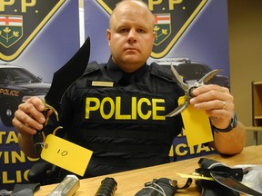 Const. Ed Sanchuk with the Norfolk County OPP shows a number of weapons that were seized from a Windham Street home on Wednesday. (SARAH DOKTOR Simcoe Reformer)