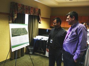 Jon Heinrichs, left, a Regional Municipality of Wood Buffalo consultant, shows resident Peter Farthing plans to complete a water main project. ANDREW BATES/TODAY STAFF