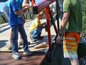 The Vanderkooi family, (from left) Evan, Shannon, Arie and Nigel, participate in the Paint that Bridge project on Aug. 6 at Rotary Park in Stony Plain. - Thomas Miller, Reporter/Examiner