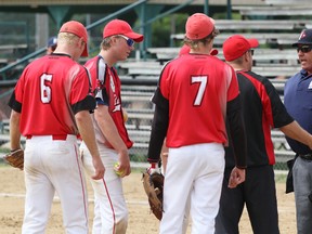 Wiarton coach Mark Hooey argues with the umpire prior to he and pitcher Ty Sebastian (centre with the ball in his hand) being ejected from the Red Devils' 5-4 win over Stratford on Thursday at the 2013 Canadian Junior Men's Fastball Championships in Owen Sound.