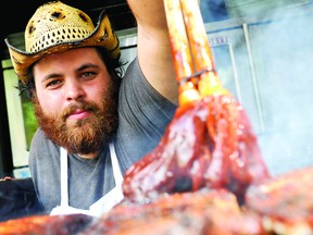 Ribber ‘Tickle’ from the ‘Kentucky Smokehouse’ sauces up some ribs at the Brockville Ribfest. Ribfest opened Thursday and runs at Hardy Park through to Sunday. (THOMAS LEE/The Recorder and Times)