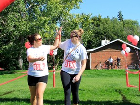Two of the nearly 200 runners from last year’s Stride: the Walk for Blood high-five as they cross the finish line. Photo supplied by Dallas Will Photogtaphy