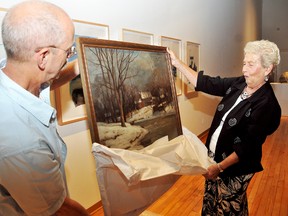 Thames Art Gallery curator Carl Lavoy and Audrey Mistele unveil a new Alexander M. Fleming painting the gallery were able to purchase because of a generous donation from Mistele. The gallery now houses over 70 original works by the Canadian artist from Chatham. PHOTO TAKEN: Chatham, On., Diana Martin/Chatham Daily News/QMI Agency