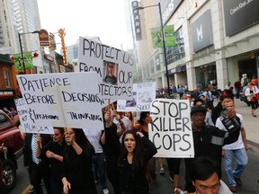 Protesters demonstrate at downtown’s Dundas Square on July 29, a day after 18-year-old Sammy Yatim was shot by police on a Dundas streetcar, which was captured on video and posted to the Internet.
MICHAEL PEAKE/TORONTO SUN