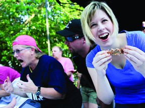Recorder and Times reporter Alanah Duffy reacts during her work team's competition during the rib-eating contest at the Brockville Ribfest Friday evening. (THOMAS LEE/The Recorder and Times)