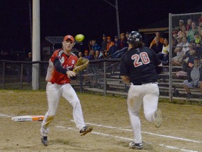 Wiarton Red Devils' first-baseman Ty Sebastian throws the ball home while Newfoundland's Johnny Doyle rumbles to first during a double life game on Friday at the 2013 Canadian Junior Men's Under-21 Fastball Championships.