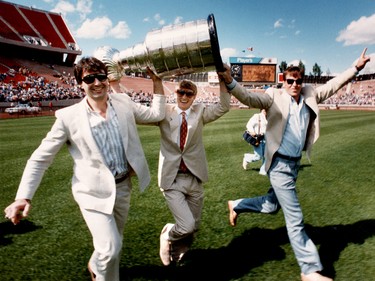 June 2, 1985. Left to right, Edmonton Oilers Paul Coffey, Wayne Gretzky and Kevin Lowe hold the Stanley Cup aloft as they run across the Commonwealth Stadium grass during a community gathering for the repeat Stanley Cup Champion Oilers at Commonwealth Stadium on June 2, 1985. The Oilers won their second Stanley Cup Championship by beating the Philadelphia Flyers in five games on May 30, 1985 in Edmonton Alta. Edmonton Sun/QMI Agency