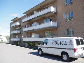 A forensic van sits outside an apartment complex at 379 Lake St. on Friday where city police are investigating a homicide.