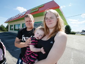 Jason Desroches, Andrea Chilcott and their 16-month-old baby in front of Flips restaurant in Brampton. (Stan Behal/Toronto Sun)