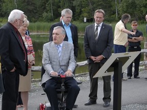 Lieutenant Colonel Alex Monseanu, CD, AdeC, Aide de Camp, left listens as Kirkland Lake Mayor Bill Enouy discusses NHL player Ted Lindsay, with Honourable Lieutenant Governor David C. Onley, while MP Charlie Angus and MPP John Vanhof listen in on the history of Kirkland Lake.