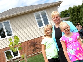 Kelly Tomkins and her two children, Emma, 10, left, and Faith, 7, right, stand in front of their newly completed home on Bristol Drive, on Saturday August 10, 2012. The Tomkins family were selected by Habitat for Humanity Chatham-Kent to purchase the home, and will be moving in by the end of the month. KIRK DICKINSON/FOR CHATHAM DAILY NEWS/ QMI AGENCY