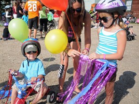 Thirteen-year-old Alyssa Fournier adjusts the bike accessories of Hudson Herzog, 2, and Paige Fournier, 9, minutes before the start of the Eva’s Ride at the train station in Sexsmith, Saturday. Fournier and her siblings all took part in the ride to support the Ronald McDonald House Northern Alberta and commemorate Eva, a local infant who lost her life to cardiac disease in summer 2011. (Elizabeth McSheffrey/Daily Herald-Tribune)