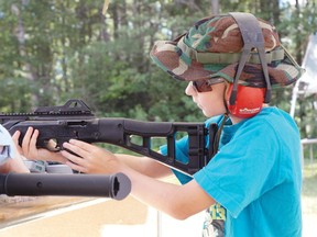 Wyatt Krueger aims a rifle at the Pembroke Outdoor Sportsman's Club's open house.