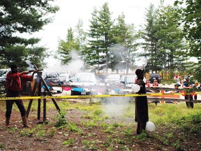 Ward Wright (left) shoots the balloons his son Morgan Wright is holding as part of the Petawawa Setter's Festival.