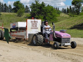 Tractor-puller Shirley Avey guns the engine as she hauls 6,800 pounds on a sled at Saturday's Big Creek Tractor Pull in Oakland. (Susan Gamble, The Expositor)