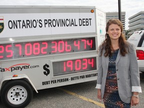 Candice Malcolm, Ontario director of the Canadian Taxpayers Federation, stands by the Debt Clock during its stop in Sudbury on Monday. Malcolm brings the clock to Peterborough Wednesday at the Farmers' Market. QMI AGENCY/THE SUDBURY STAR
