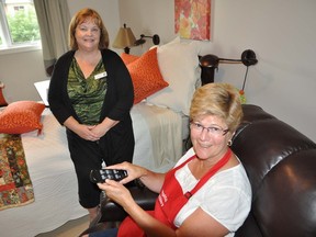 Nancy Parks, executive director of Hospice Prince Edward, and Peggy Payne (sitting in chair), president of The Prince Edward County Memorial Hospital axillary, sample one of three newly-equipped palliative care rooms at the residential hospice site in Picton on Friday. The equipment was purchased with PECMH axillary fundraising dollars.