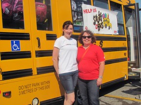 United Way Oxford staff Amanda Kreiger, left, and Kelly Gilson pose in front of the stocked bus at last year's Stuff the Bus event in Woodstock. (Submitted photo)
