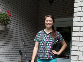 Emily Hazell, 19, wears the scrubs she is bringing to Tanzania, where she will volunteer for two weeks with a dentist and other healthcare professionals at a clinic. MICHAEL PEELING/The Paris Star/QMI Agency