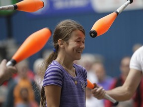 Nine-year-old Ashlyn Pallot laughs nervously as juggling pins are tossed around her during last weekend’s annual Buskerfest. The popular three-day event features various street performers showcasing entertaining acts in the city’s downtown. Buskerfest draws young and old yearly to take in the entertainment.