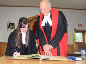 (L to R) Crystal Will signs her official document to enter the Saskatchewan Bar Association with Justice Geoff Dufour of the Court of Queen’s Bench during her swearing in ceremony on Monday, August 12 at Melfort Court of Queen’s Bench.