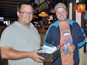 Alex's uncles Vince Hiebert, left, and Terry Friesen handle the 50/50 draw at a steak supper fundraiser held at Tavern United Saturday night. The 50/50 became 100 when the winner donated back her almost $400 pot to help the sick lad. (CLARISE KLASSEN/PORTAGE DAILY GRAPHIC/QMI AGENCY)