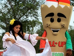 Edmonton Latin Festival Dancer Ingrid Torres and Edmonton Food Bank mascot Fill-up, dance during the launch of the Edmonton Food Bank's food drive at the Heritage Festival, at Hawrelak Park in Edmonton, Alta., Friday Aug. 2, 2013. The food bank will be collecting non-perishable food items, cash donations, as well as unused food tickets during the festival. David Bloom/Edmonton Sun/QMI Agency