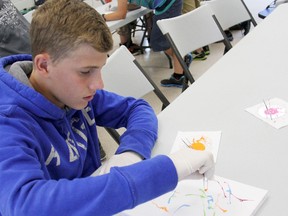 Ethan Paxton, 13, of Chatham, On., experiments with using maggots dipped in water soluble paint to make art during the Chatham-Kent police Kids Cop Camp experience on Tuesday, Aug. 13, 2013, near Chatham, Ont. The day included a talk by one of Canada's only two certified forensic entomologists, Dr. Sherah VanLaerhoven, professor of  biology at the University of Windsor. VICKI GOUGH/ THE CHATHAM DAILY NEWS/ QMI AGENCY