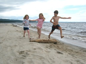 Amelia Madden, 4, along with Isadora Furey and Pico Madden, both 7, jump over a log as they race down the beach at Sand River in Lake Superior Provincial Park. The children and their families were visiting the area from Nova Scotia and Toronto.